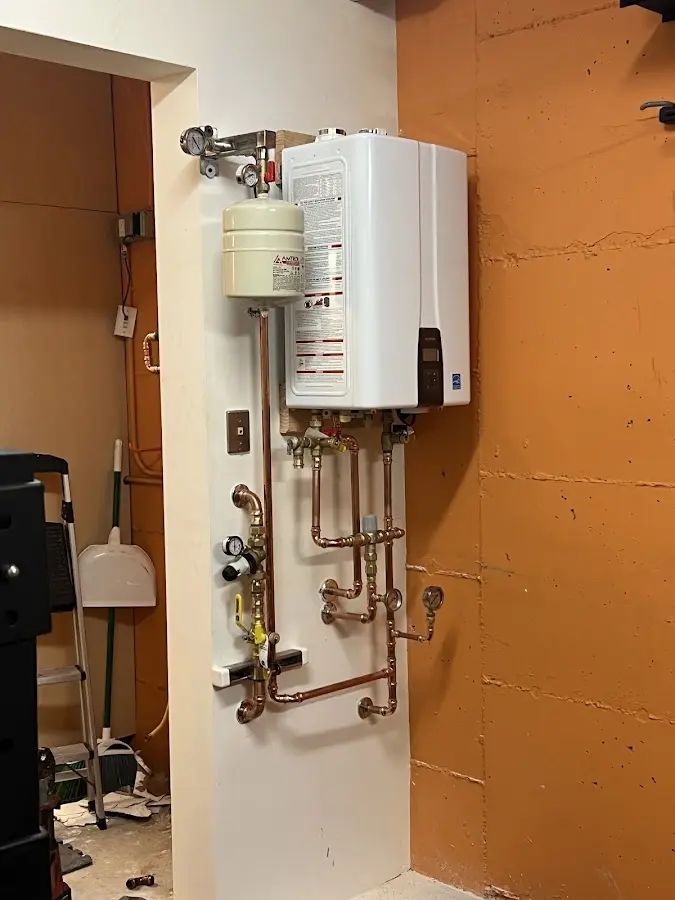 Plumbing technician inspecting water heater connections in London Britain